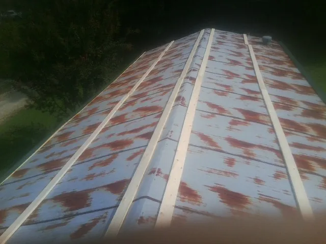 Rusted metal roof panels with new wood purlins before replacement — Storm Damage Roof Repair in Marstons Mills by Roofing Brothers
