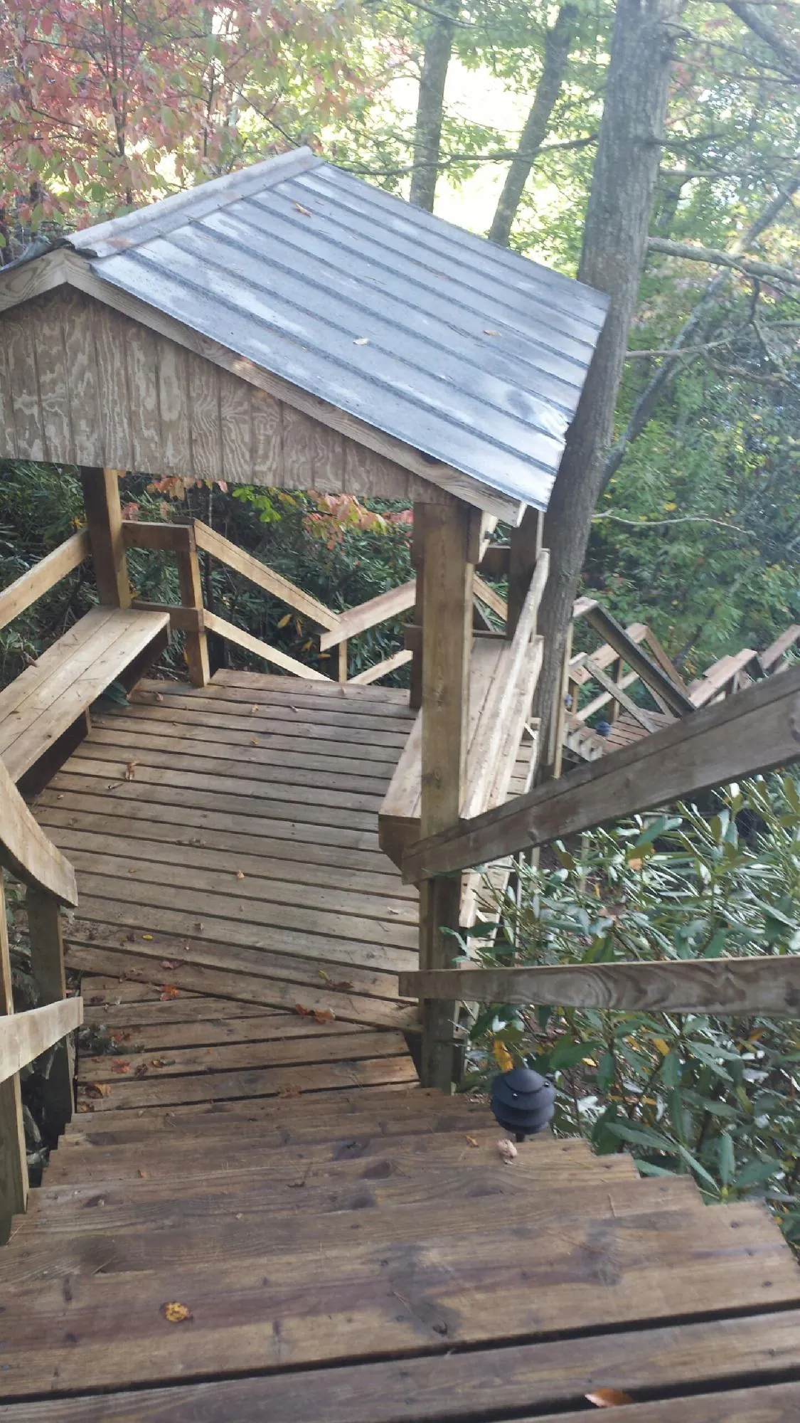 Metal roofed shelter over wooden steps on a wooded walkway — Skylight Repair & Installation work by our crew in Marstons Mills