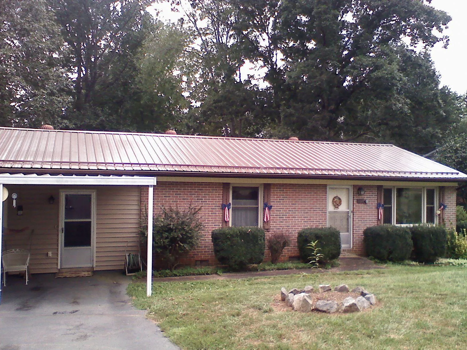 Bronze metal roof and carport on a brick ranch home — Roof Repair work by our crew in Marstons Mills